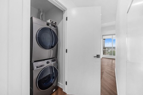 A washer and dryer are stacked in a small space.