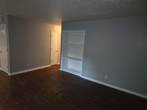 A room with a white door and a white shelf unit.