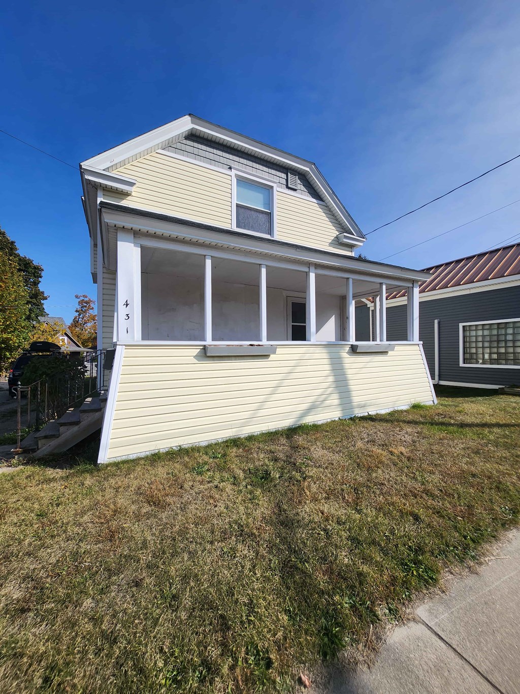 A house with a white front porch and a brown roof.