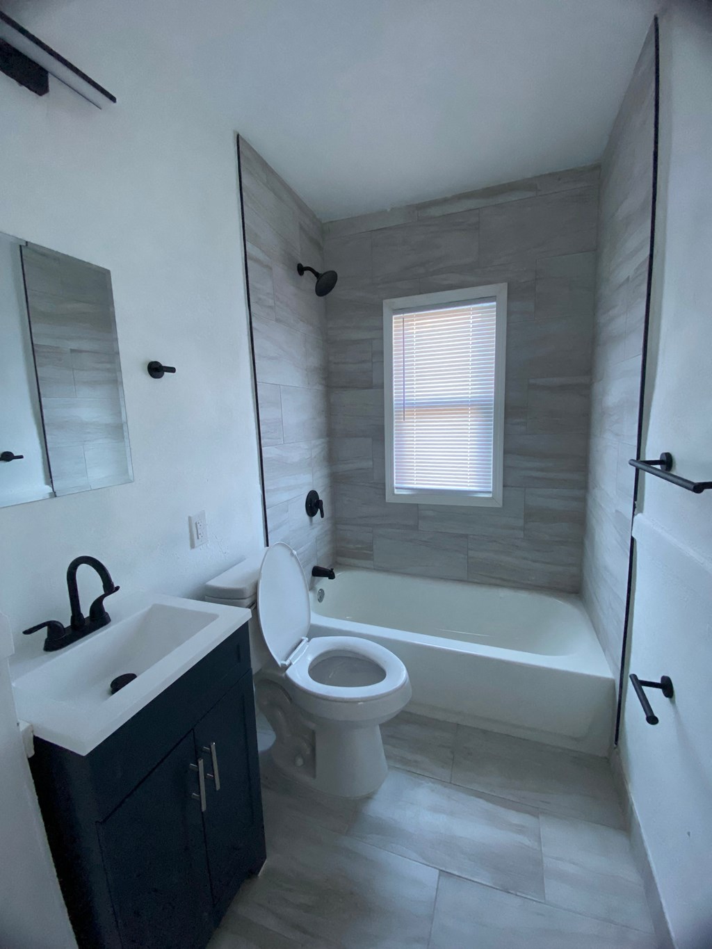 A bathroom with a toilet, sink, and tub.