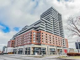 A modern multi-story building with a red brick facade and a white top.