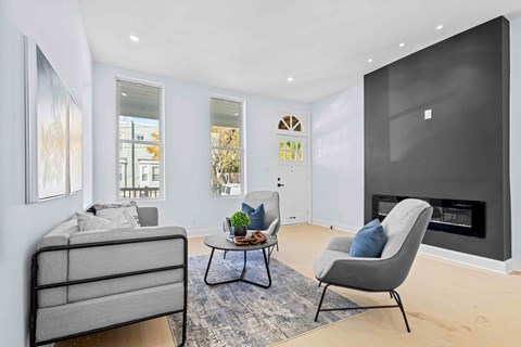 A grey sofa and chair are in front of a fireplace in a modern living room.
