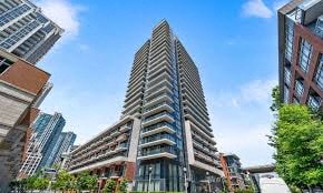 A tall building with a unique design stands out among other buildings.