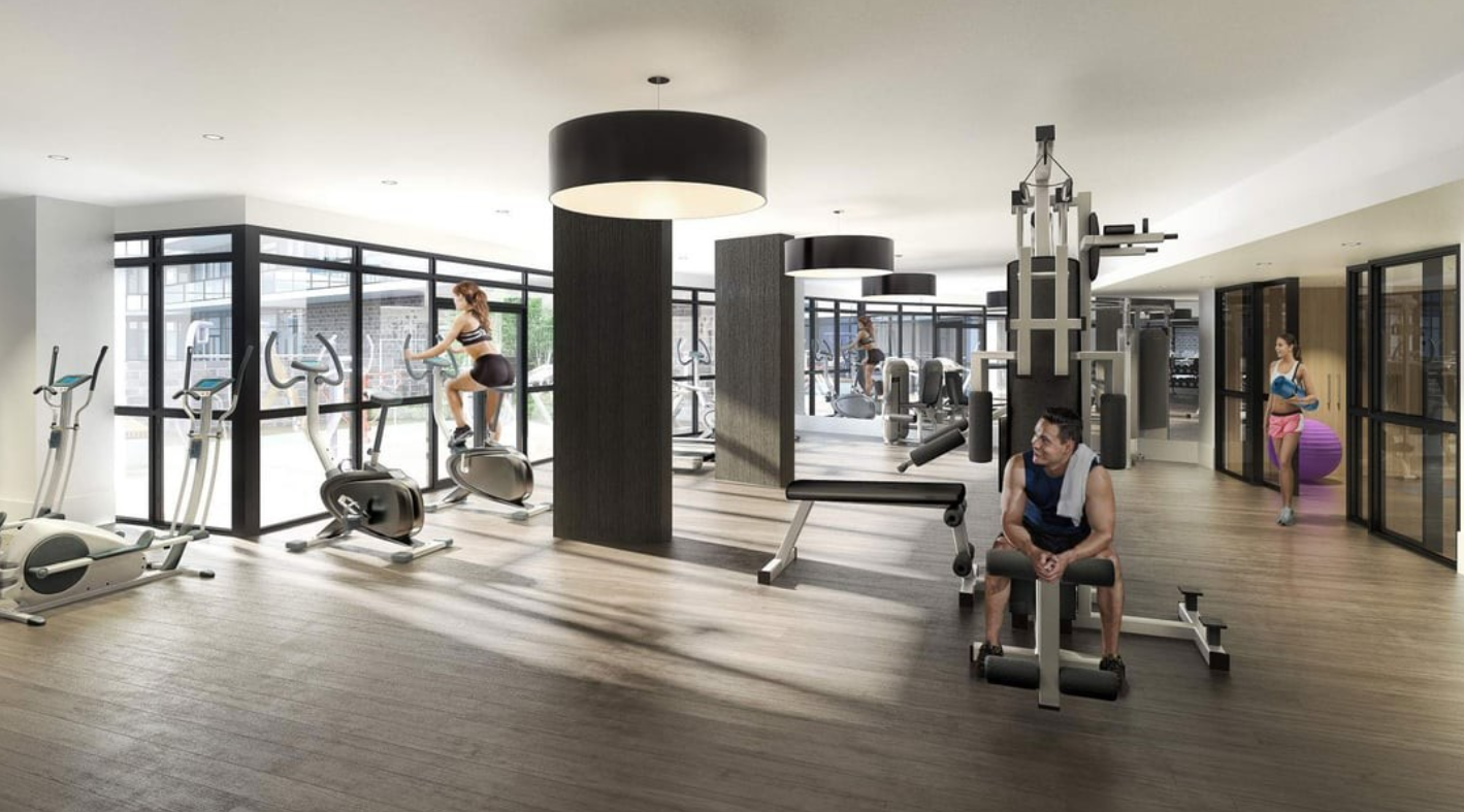 A gym with a man working out on a rowing machine.