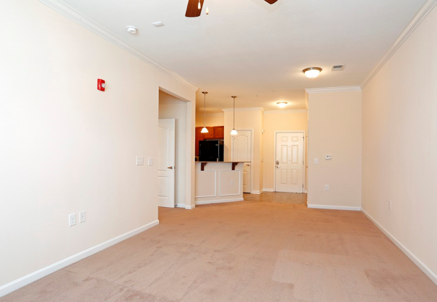 the living room and kitchen of an empty house with white walls