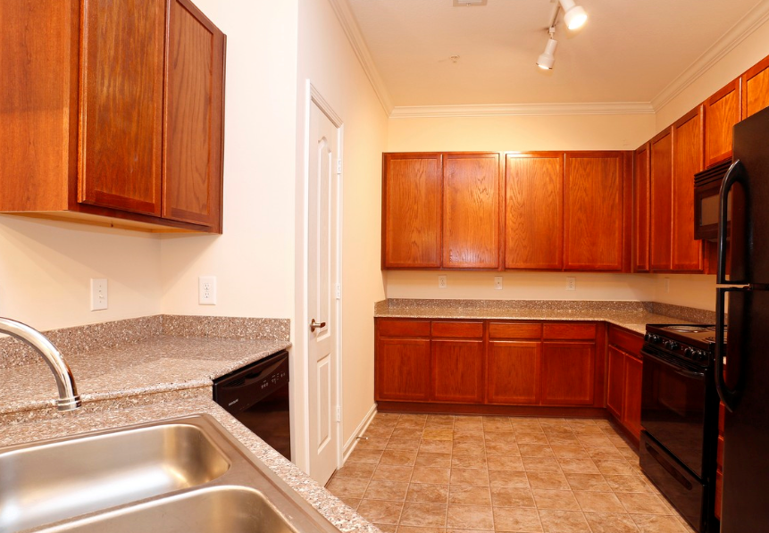 a kitchen with granite counter tops and wooden cabinets