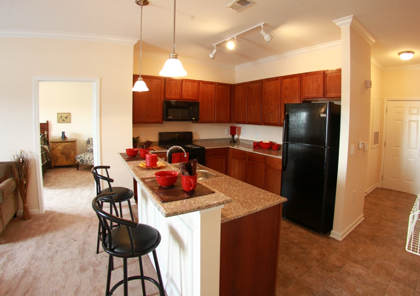 a kitchen with a island and a black refrigerator