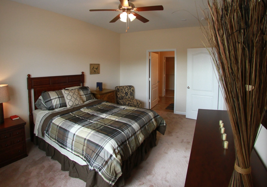 a bedroom with a bed and a ceiling fan