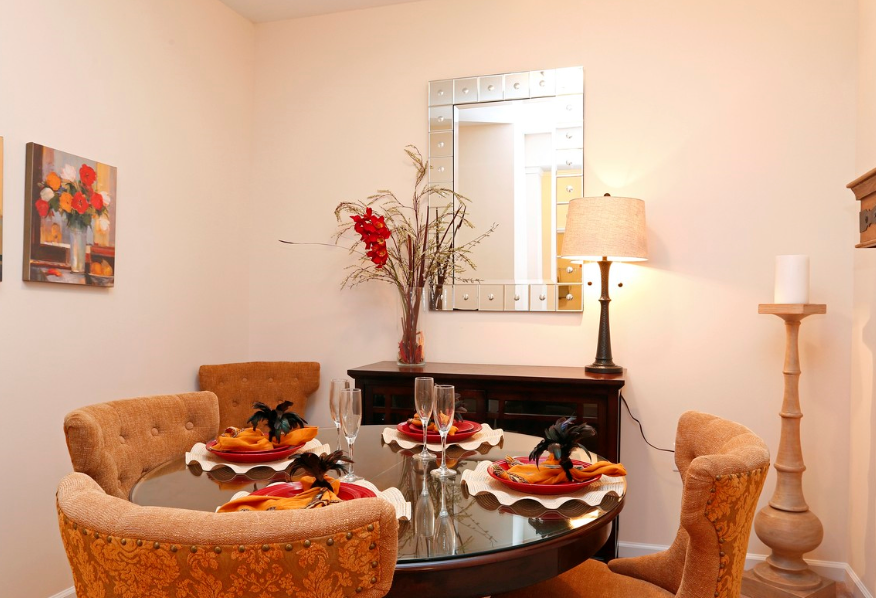 a dining room with a table and chairs and a mirror