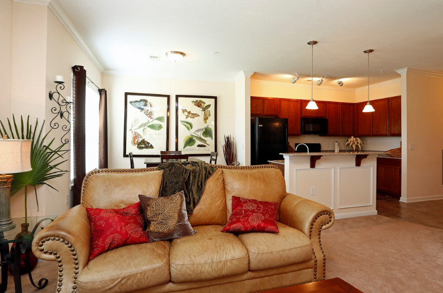a living room with a couch and a kitchen
