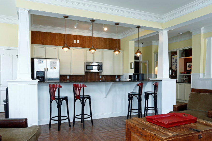an open kitchen and living room with a bar and stools