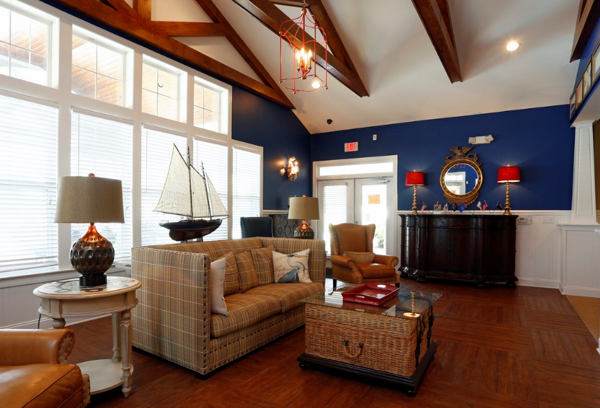a living room with blue walls and large windows