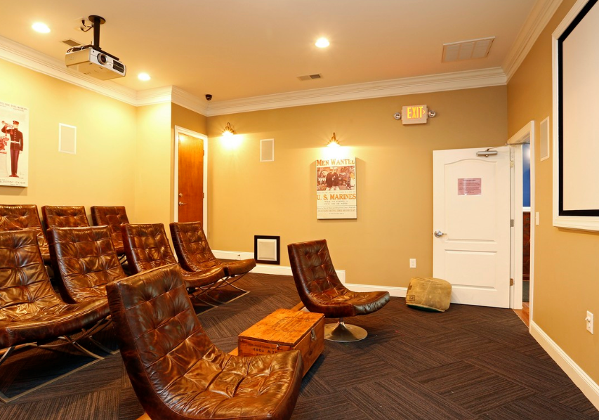 a conference room with leather chairs and a projector