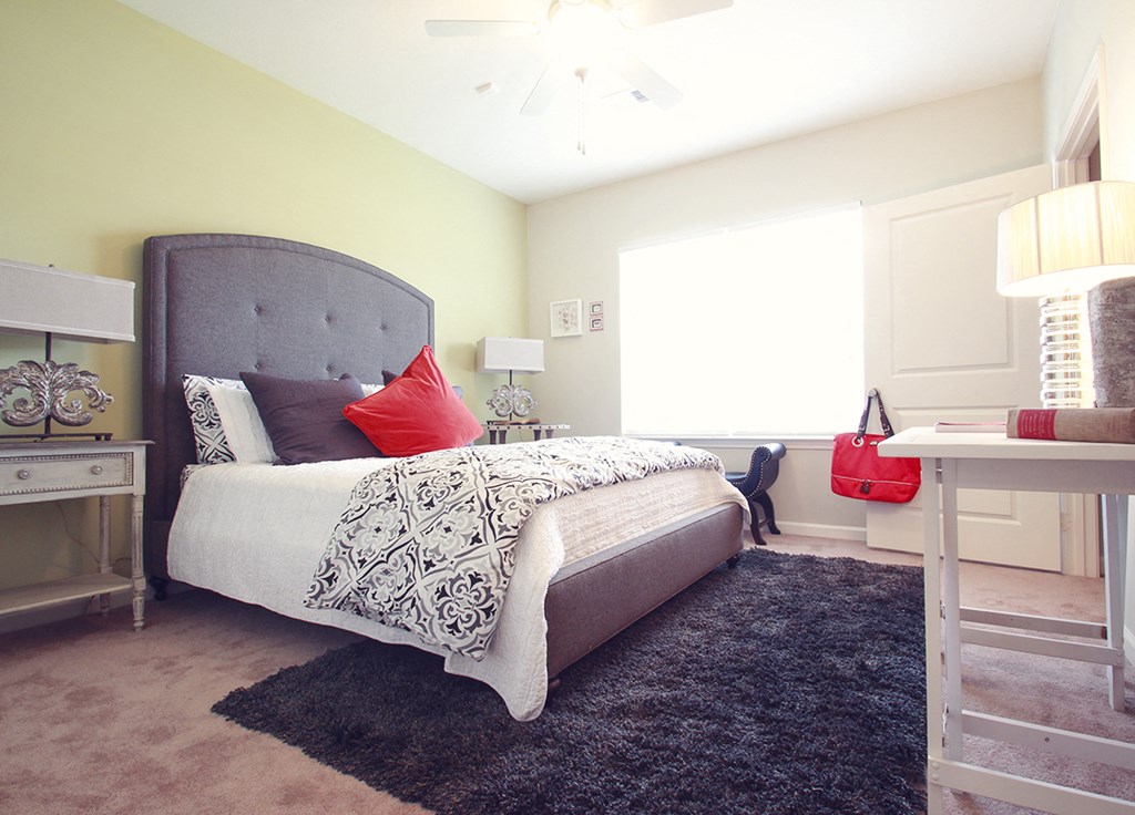 a bedroom with a bed and a desk and a window