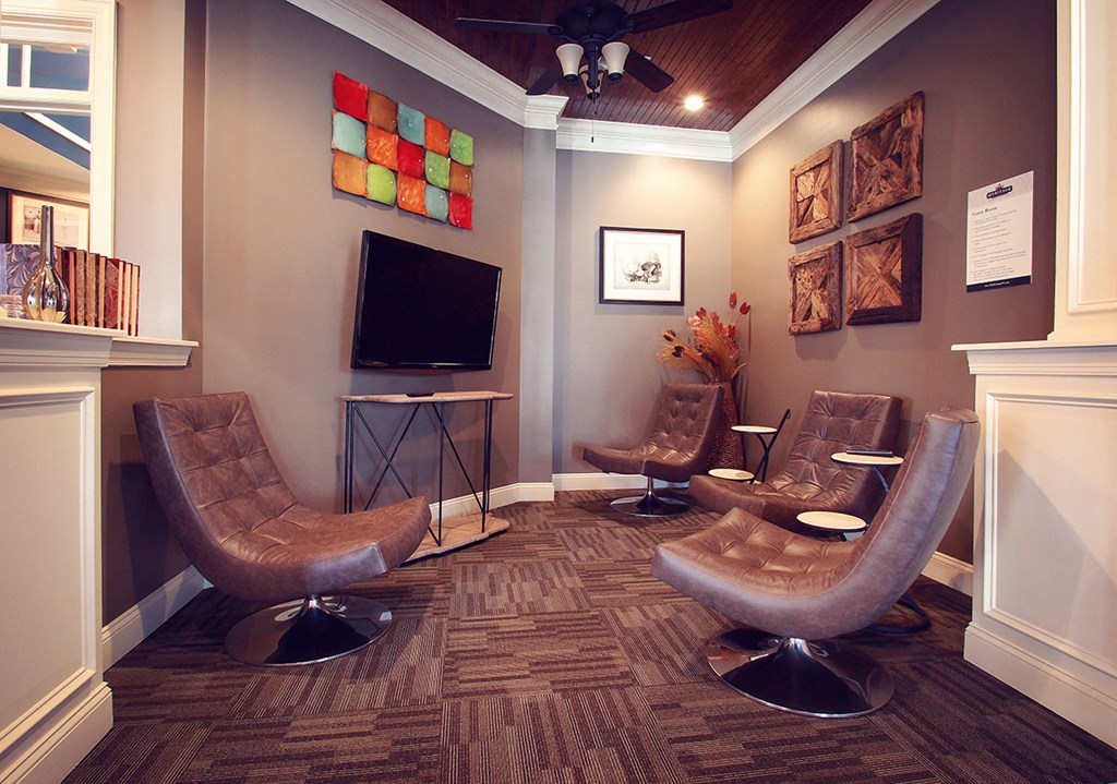 a living room with three chairs and a television
