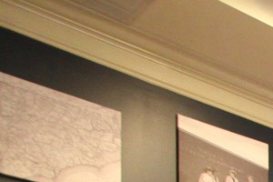 a dining room table with chairs and maps on the wall