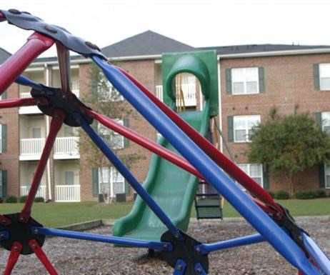 a slide on a playground in front of an apartment building