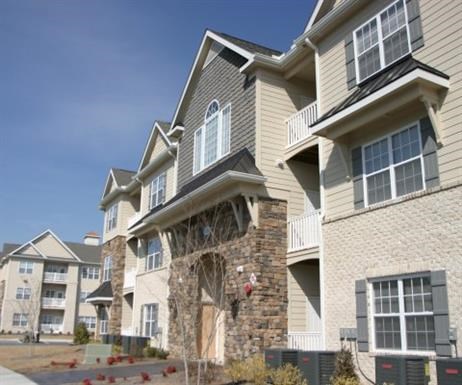 A large apartment building with a stone chimney and balconies.
