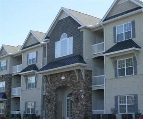 A row of houses with balconies and stone pillars.