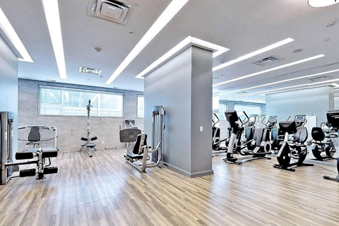 A gym with a variety of equipment including treadmills, weights, and exercise machines.