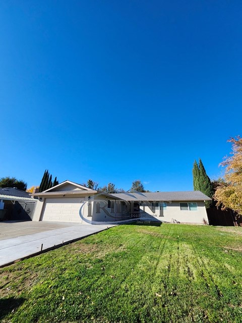 A house with a garage and a driveway in front of it.