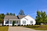 A white house with a grey roof and a porch.