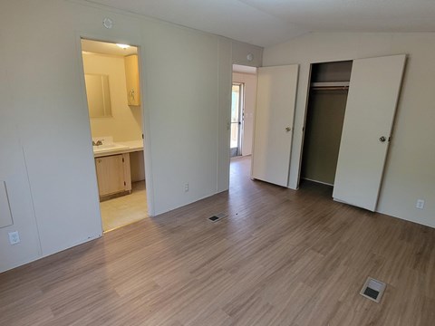 A room with wooden flooring and white walls.