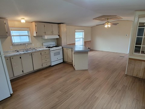 A kitchen with wooden floors and white appliances.