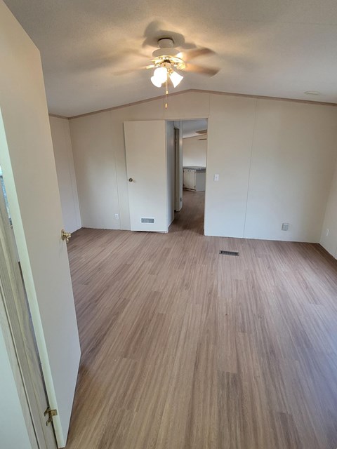 A room with a ceiling fan and light fixture.