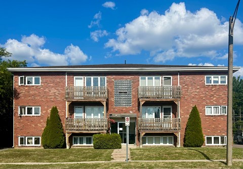 A red brick building with a balcony in the middle.