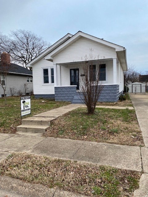 A small white house with a grey front yard.