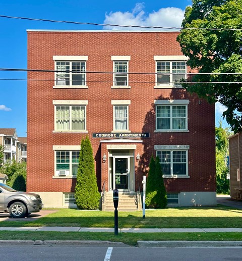 A red brick building with the words Cudmore Apartments on the front.