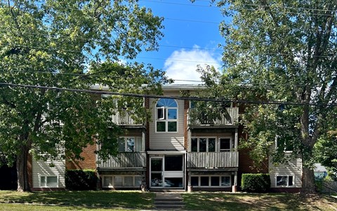 A two-story apartment building with a balcony on the second floor.