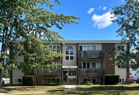 A multi-story apartment building with a balcony on the second floor.