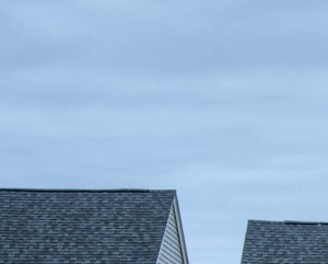 a row of houses with cars parked in a parking lot