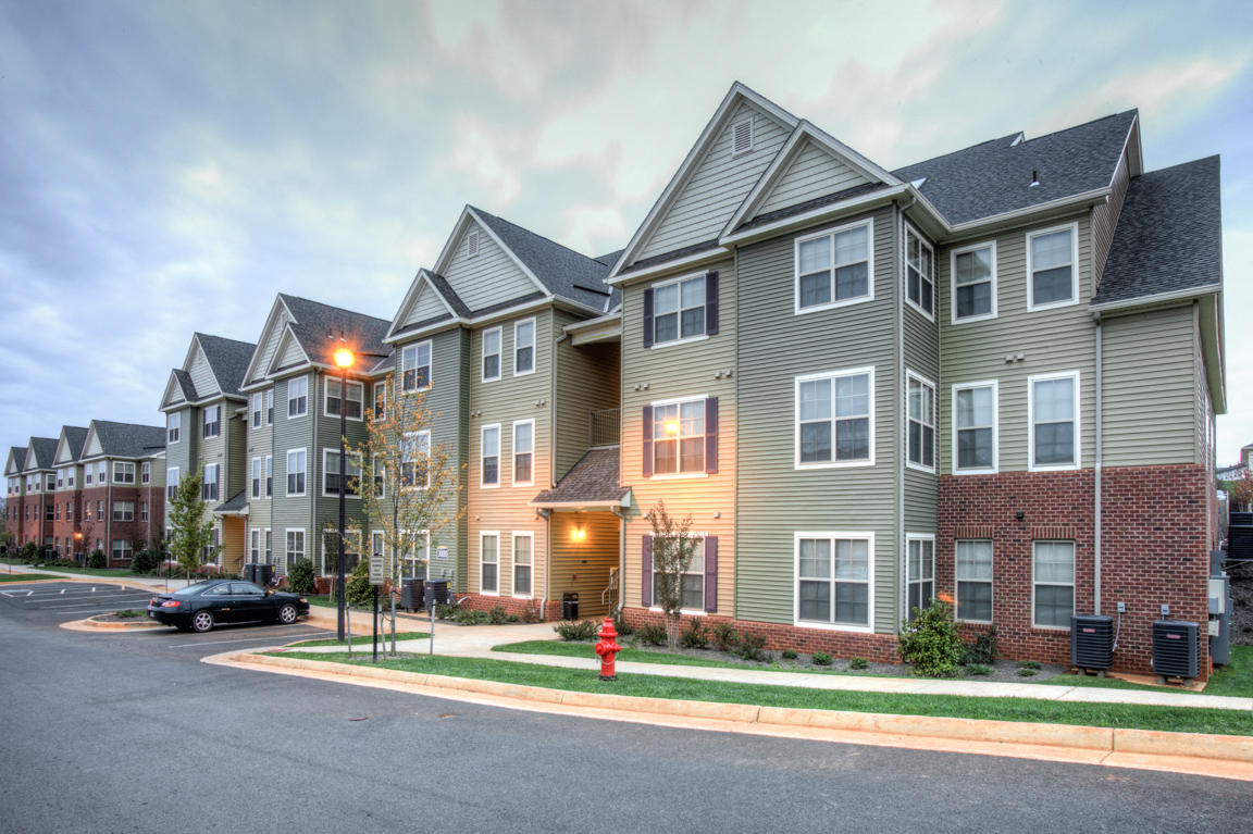 a row of townhouses on a street corner with a red fire hydrant