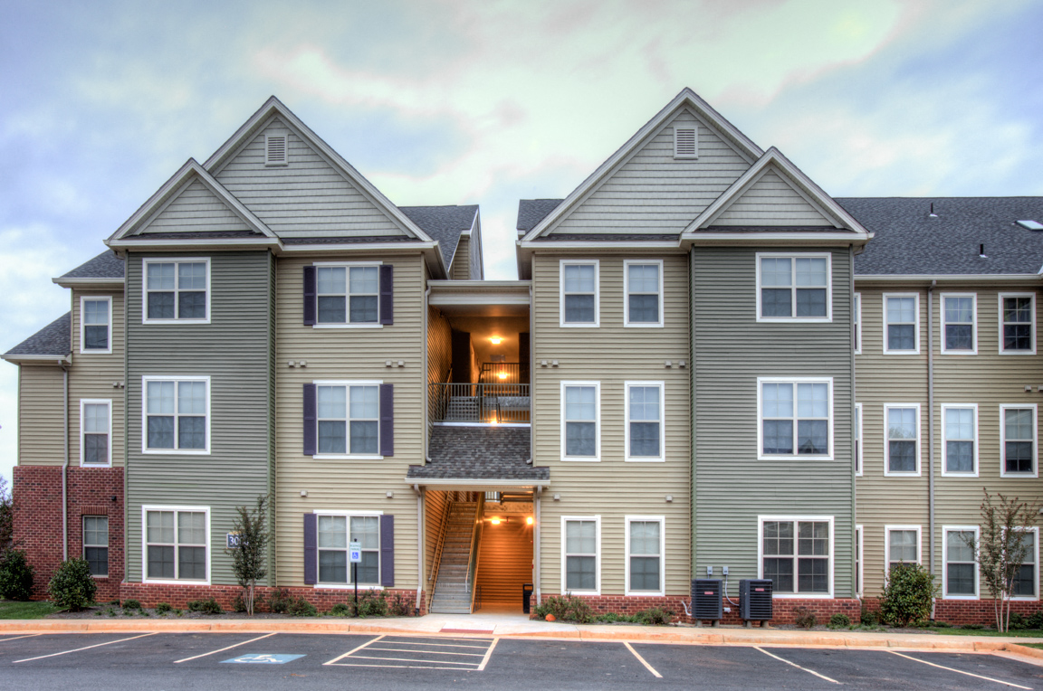 an apartment building with an empty parking lot