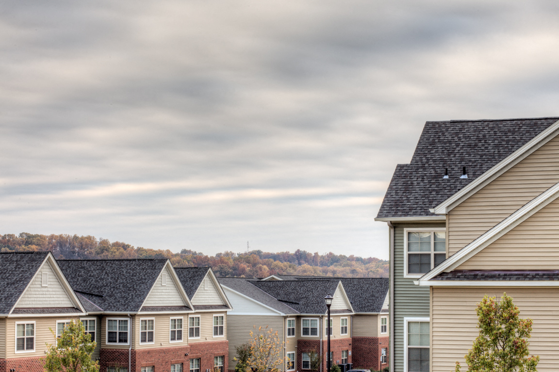 a row of houses with a cloudy sky in the background