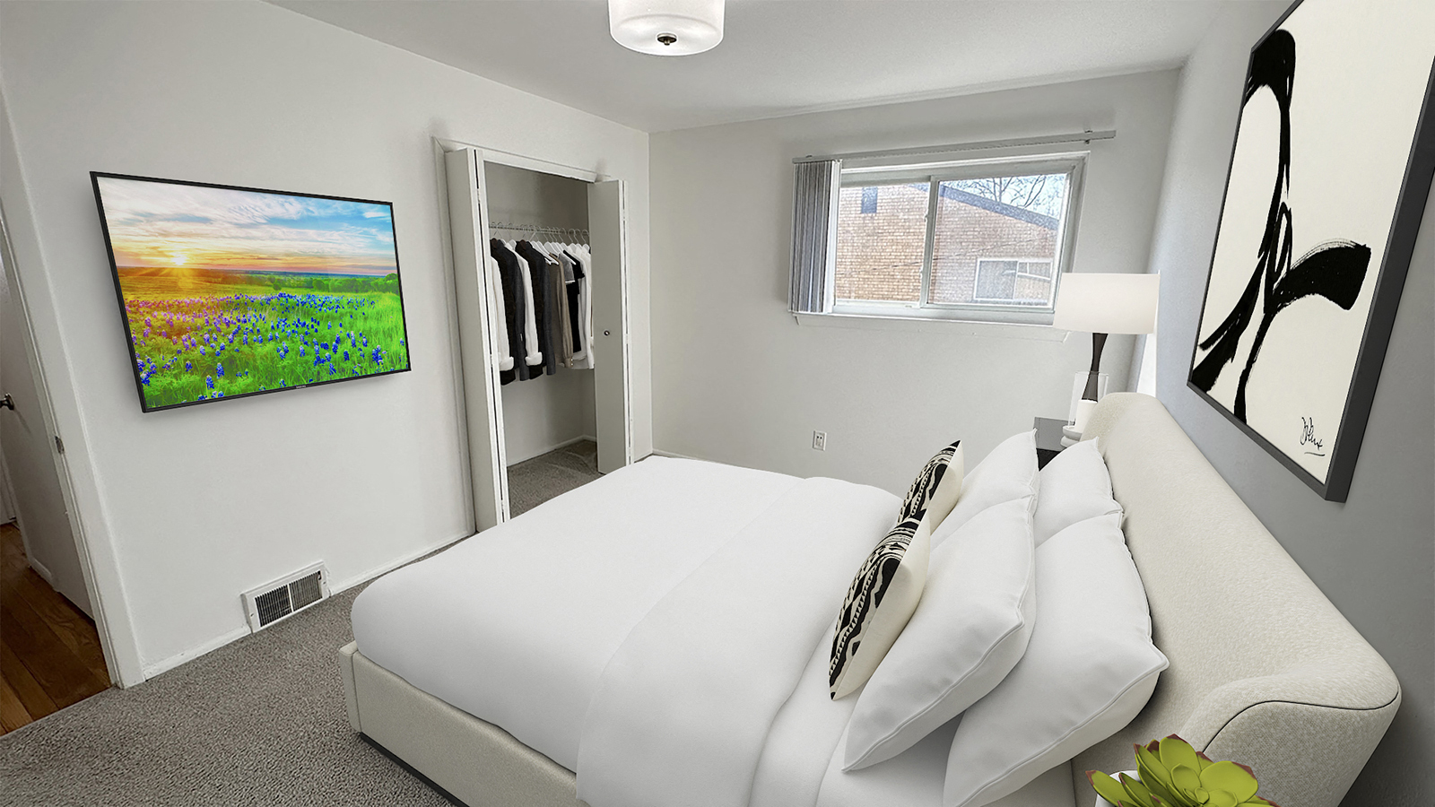 A bedroom with a large bed and a painting on the wall.