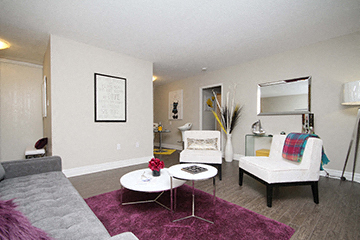 A living room with a grey couch and a white chair.