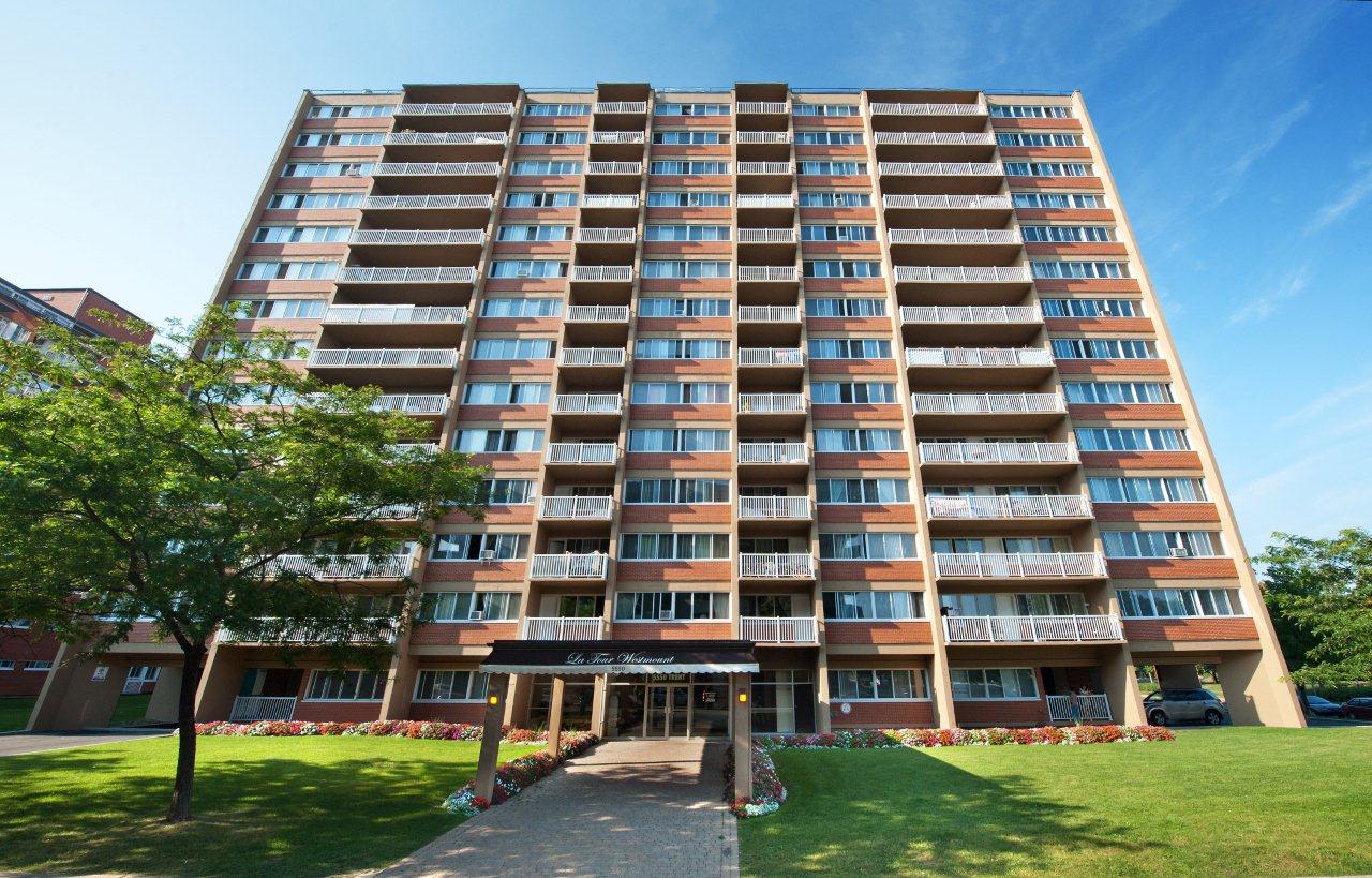 A large apartment building with a grassy area in front.