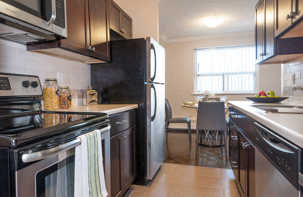 A kitchen with black appliances and brown cabinets.
