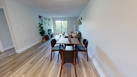 A dining room with a wooden table and chairs.