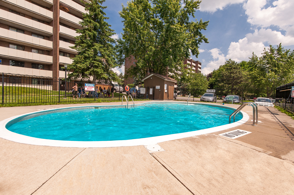 A small pool with a concrete floor and a concrete sidewalk.