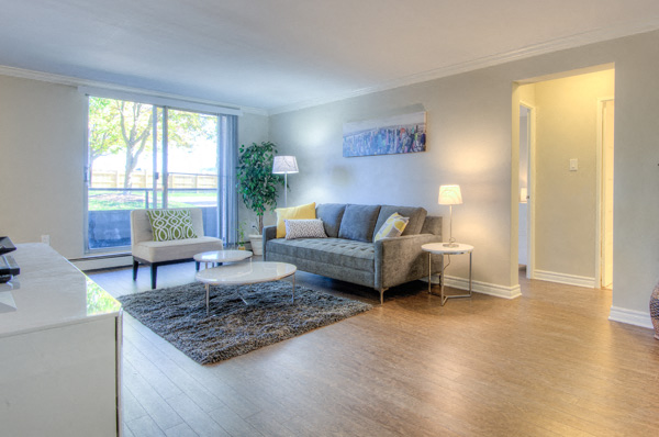 A living room with a grey couch and a white coffee table.