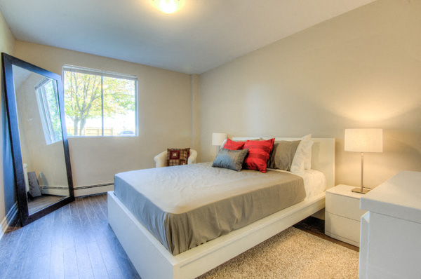 A bedroom with a large bed and a window.