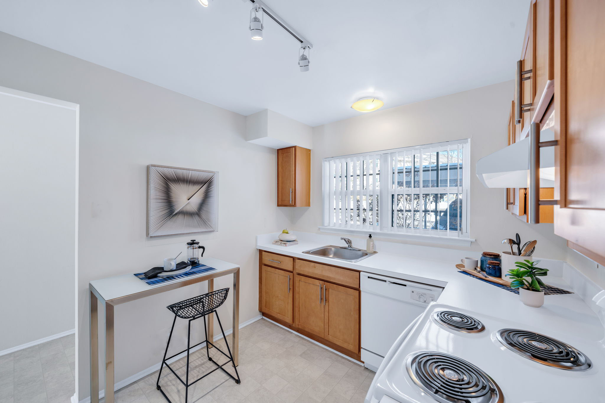 A kitchen with a white stove top oven and a white counter top.
