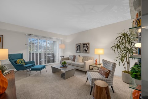 A living room with a blue chair and a grey couch.