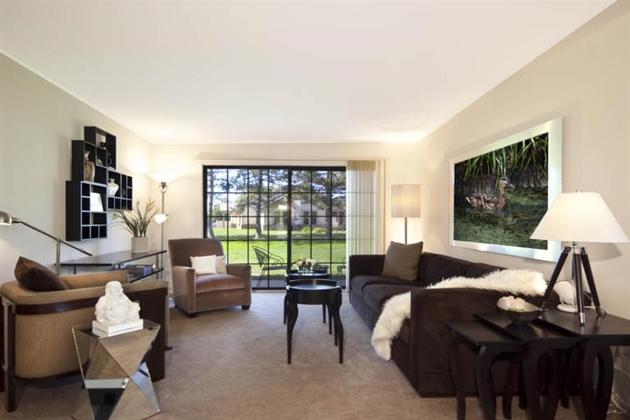 a living room with a couch and chairs and a large window