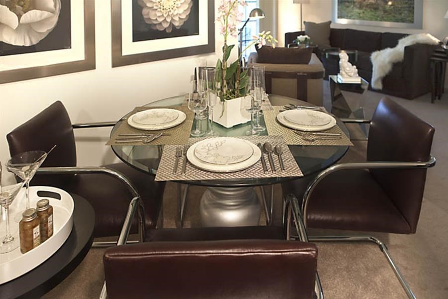 a dining room with a glass table and chairs